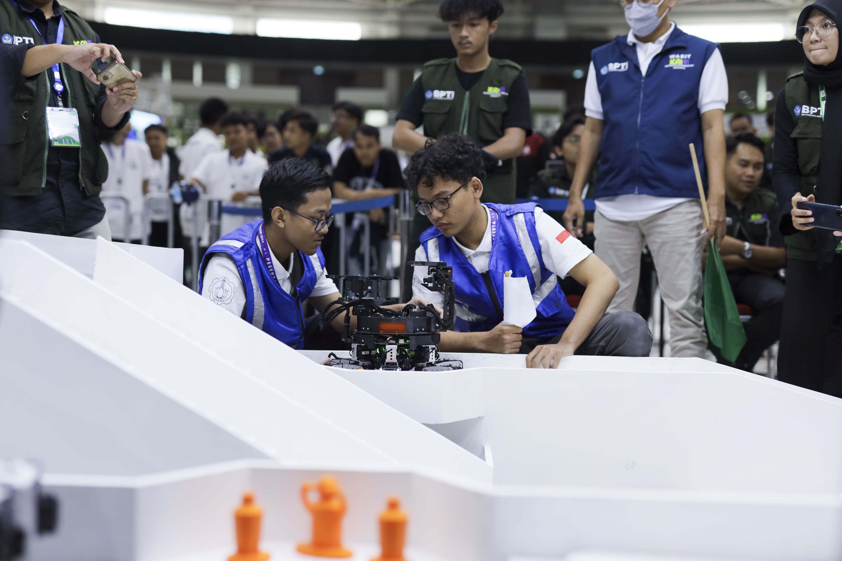 Team members operating a robot on the competition field
